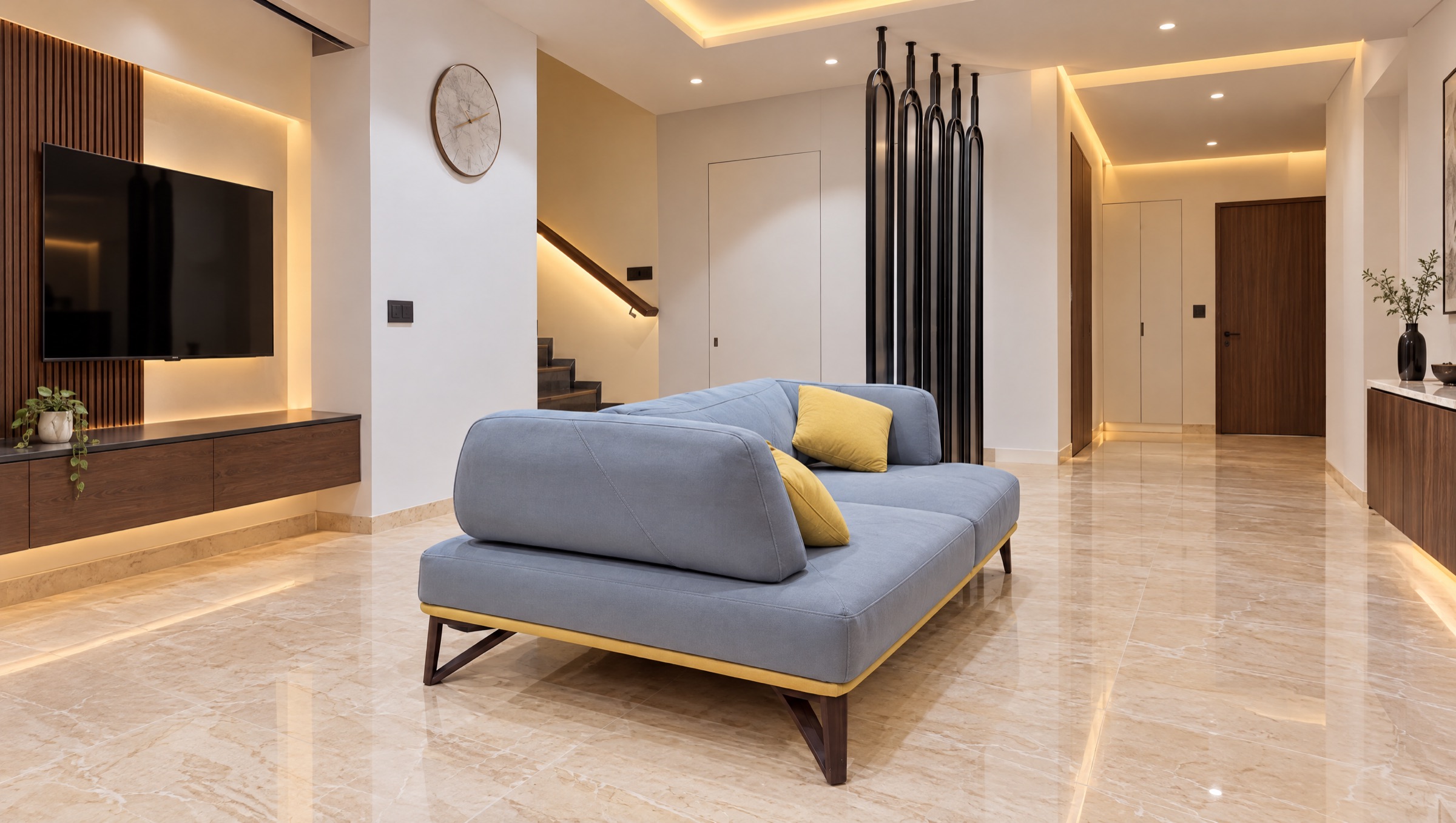 Living room with a low blue-grey sofa, mustard cushions and a black sculpted screen